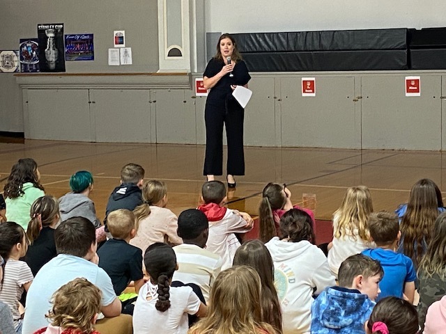 Author Beth Vrabel stands in front of a group of Martin Warren students as she presents in the gymnasium